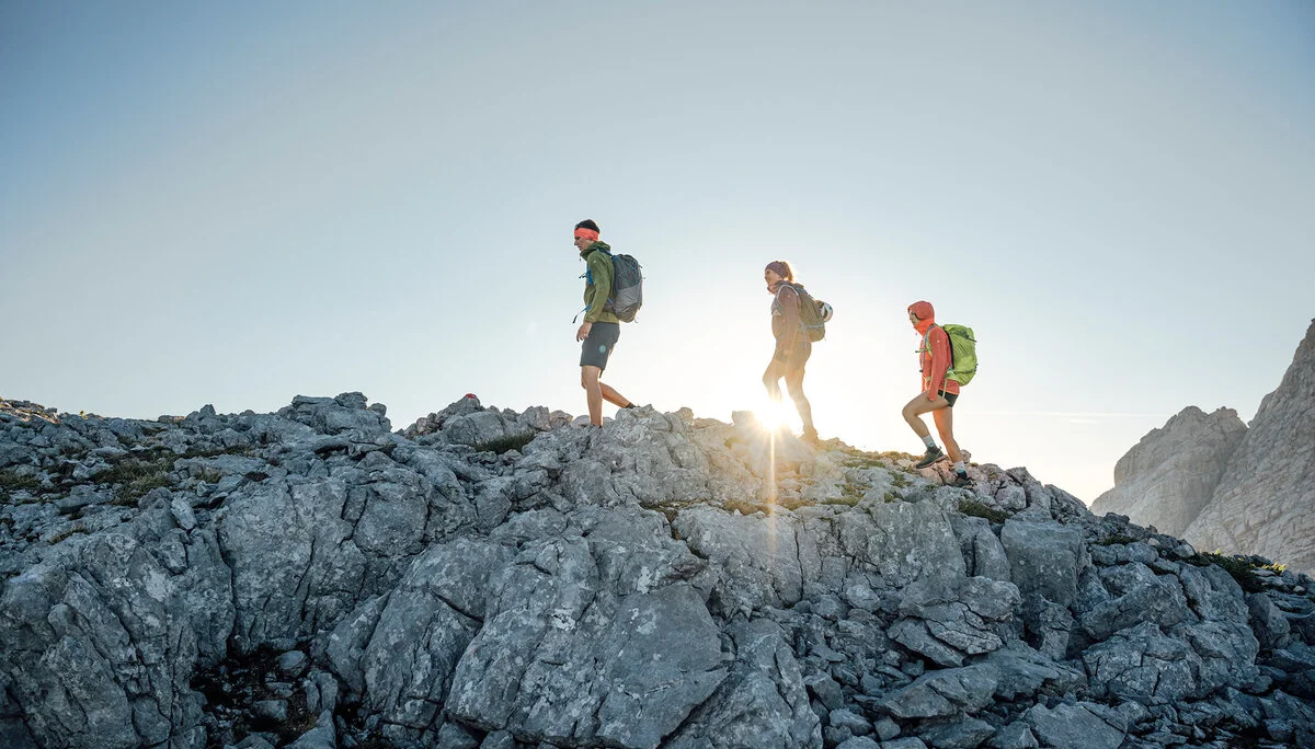 Drei Persinen besteigen im Sonnenaufgang einen Gipfel | © DAV / Julian Rohn